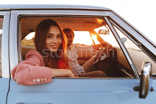 Beautiful smiling young woman sitting inside a car Stock photo © deandrobot