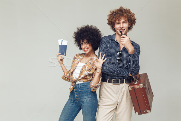 Retro loving couple holding suitcase passport and tickets. Stock photo © deandrobot