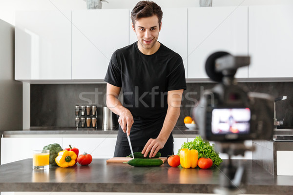 Handsome young man filming his video blog episode Stock photo © deandrobot