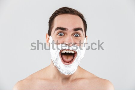 Portrait of playful guy with dark short hair having fun while sh Stock photo © deandrobot