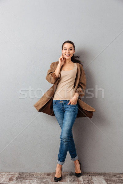 Full length of a smiling young asian woman twisting around Stock photo © deandrobot