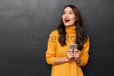 Happy woman in sweater and headphones listening music by smartphone Stock photo © deandrobot
