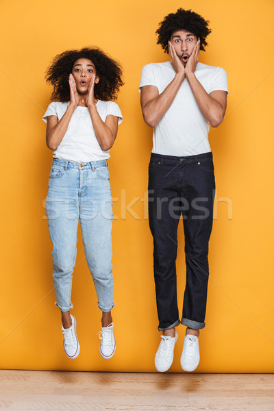 Full length portrait of a surprised young afro american couple Stock photo © deandrobot