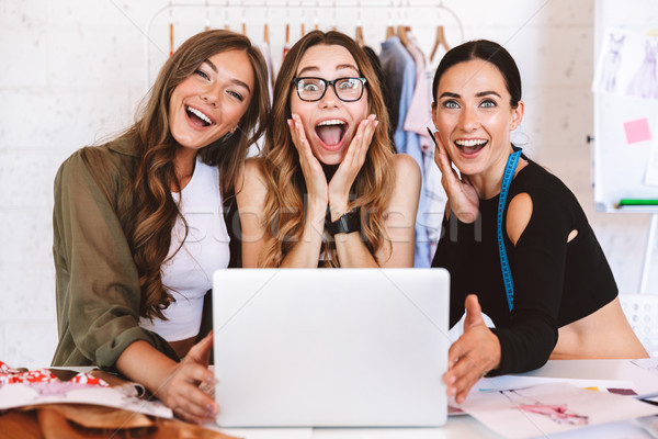 Three excited young women clothes designers Stock photo © deandrobot