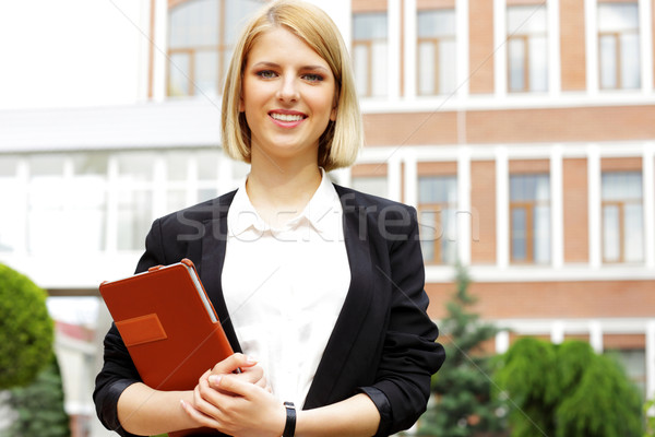 Portrait of a young smiling woman holding tablet computer outdoors Stock photo © deandrobot