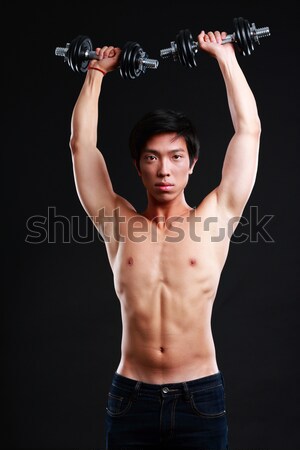 Happy asian muscular man with his arms stretched out on black background Stock photo © deandrobot