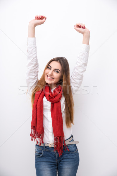 Smiling woman with raised hands up over gray background Stock photo © deandrobot