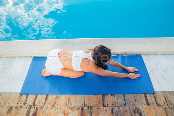 Girl working out on yoga mat outdoors Stock photo © deandrobot