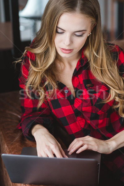 Belle concentré Homme utilisant un ordinateur portable séance canapé [[stock_photo]] © deandrobot