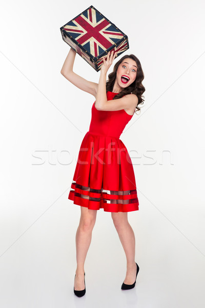 Excited pretty young curly woman throwing vintage suitcase in camera Stock photo © deandrobot