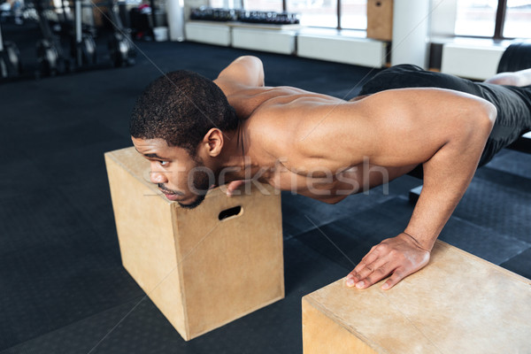 Muscular fitness man doing push-ups in the gym Stock photo © deandrobot