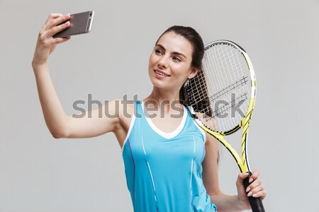 Happy woman holding tennis racquet and ball Stock photo © deandrobot