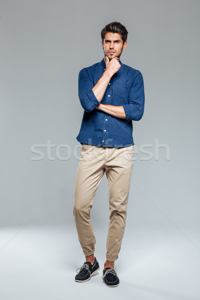 Full length portrait of a thoughtful man looking at camera Stock photo © deandrobot