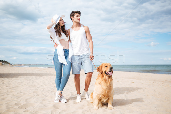 Couple walking with dog on the beach in summer Stock photo © deandrobot