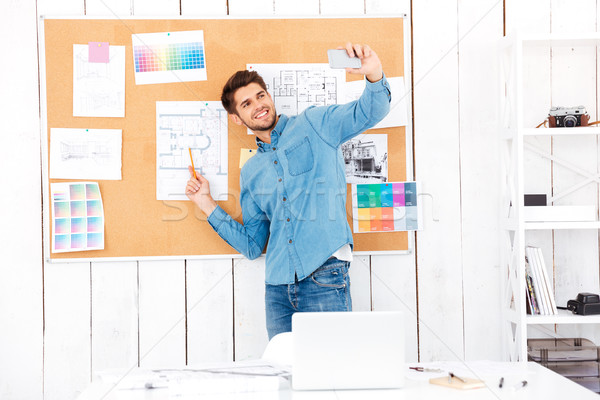 Businessman making selfie while standing in front of task board Stock photo © deandrobot