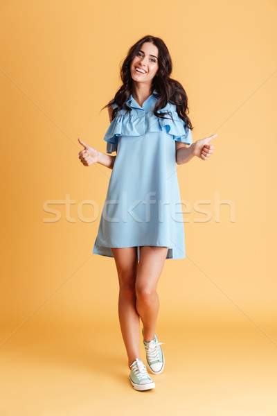 Full length portrait of charming woman showing thumbs up Stock photo © deandrobot
