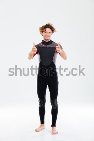 Happy joyful sportsman in diving suit showing thumbs up Stock photo © deandrobot