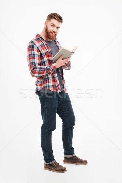 Férfi kockás póló tart könyv néz Stock fotó © deandrobot