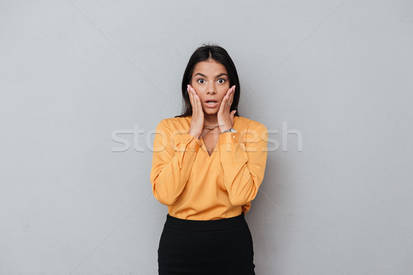Stock photo: Portrait of a surprised young business woman looking at camera