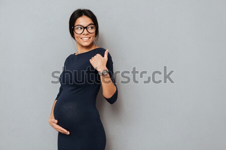 Happy pregnant business lady standing with arms crossed Stock photo © deandrobot
