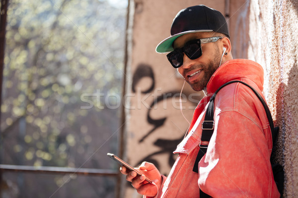 Stock photo: Happy stylish afro american man in sunglasses listening music