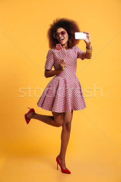 Full length portrait of a cheerful afro american woman Stock photo © deandrobot