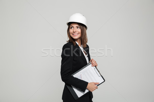 Portrait of a smiling woman in hard hat and suit Stock photo © deandrobot
