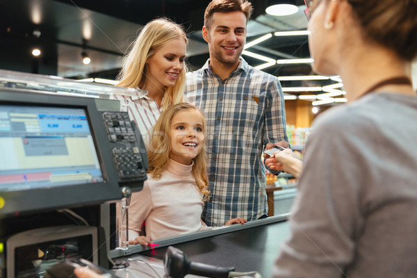 Jeunes famille payer carte de crédit magasin affaires [[stock_photo]] © deandrobot