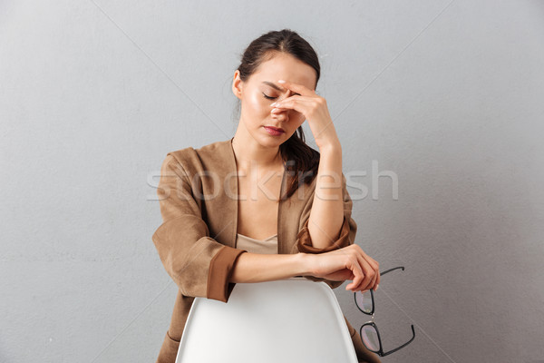 Portrait of a tired young asian woman in eyeglasses Stock photo © deandrobot