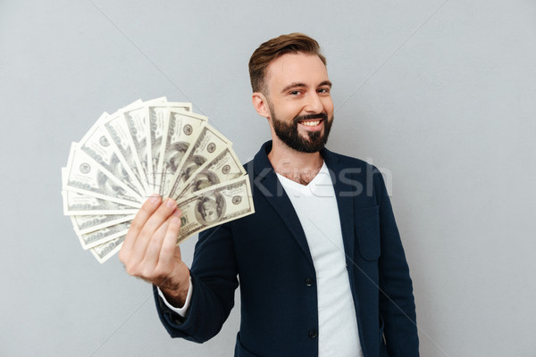 Pleased bearded man in business clothes showing money Stock photo © deandrobot