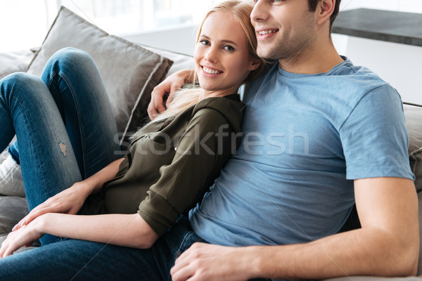 Young blonde lady looking camera while sitting with her man Stock photo © deandrobot