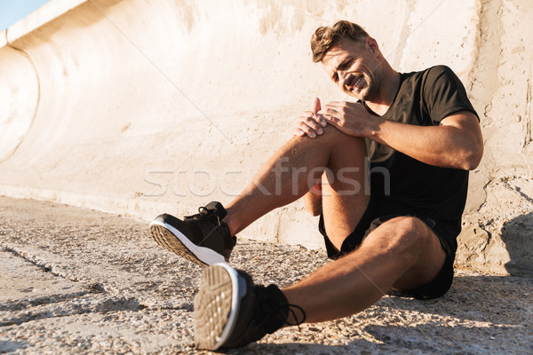 Portrait of an injured sportsman in pain Stock photo © deandrobot