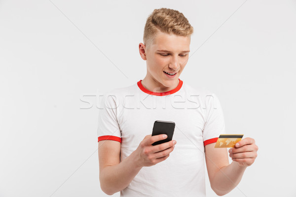 Portrait of a smiling teenage boy holding mobile phone Stock photo © deandrobot