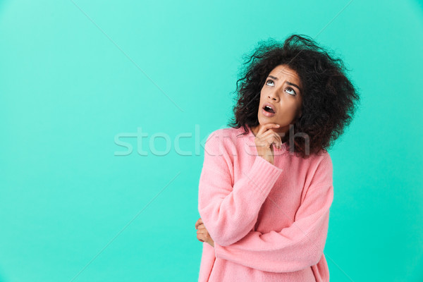 Image of puzzled brunette woman in pink shirt looking upward on  Stock photo © deandrobot