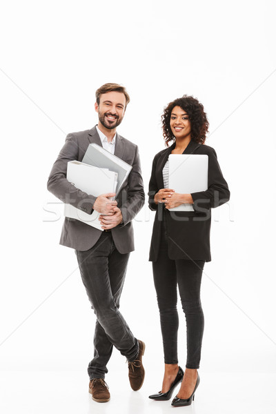 Full length portrait of a business couple holding folders Stock photo © deandrobot