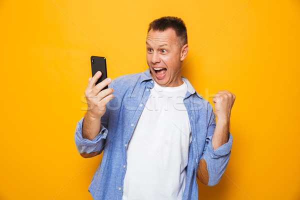 肖像 興奮 中年男子 看 手機 孤立 商業照片 © deandrobot