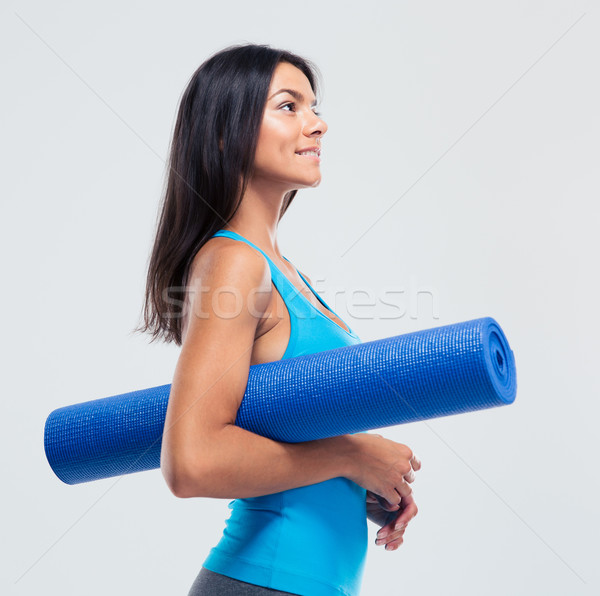 Happy sports woman holding yoga mat  Stock photo © deandrobot