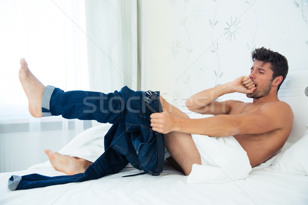 Stockfoto: Man · bed · dressing · jeans · portret · home