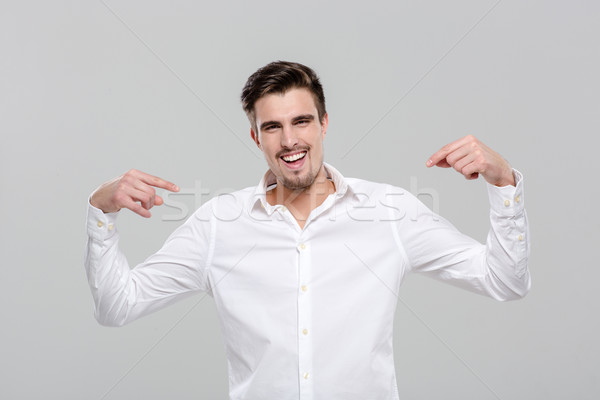 Smiling confident man pointing on himself Stock photo © deandrobot