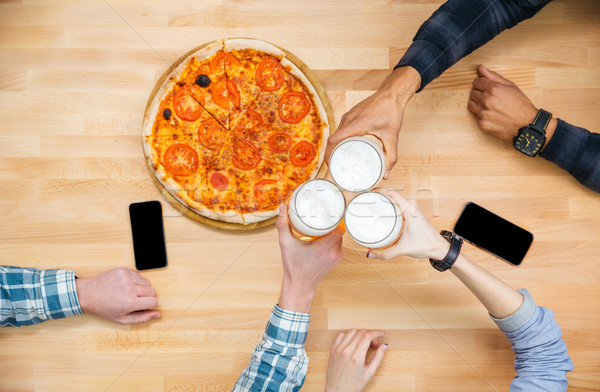 Group of friends eating pizza and drinking beer Stock photo © deandrobot