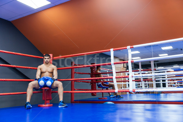 Stock photo: Boxer sitting in boxing ring 
