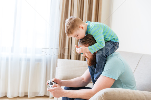 Man playing computer games while little son covering his eyes Stock photo © deandrobot