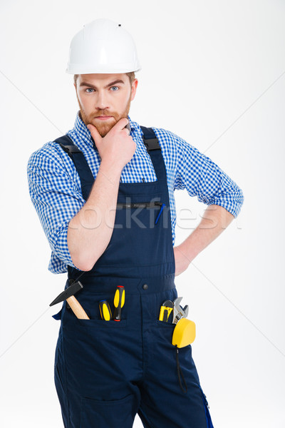 Thoughtful serious young builder standing and thinking Stock photo © deandrobot