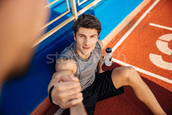 Fitness man with water bottle needs help at the stadium Stock photo © deandrobot
