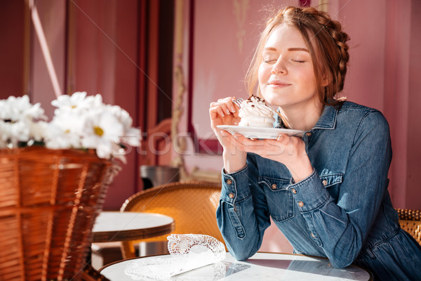 Happy woman eating sweet tasty cupcake in outdoor cafe Stock photo © deandrobot