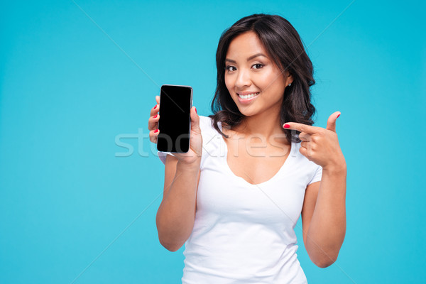 Young vietnamese woman pointing finger on blank smartphone screen Stock photo © deandrobot