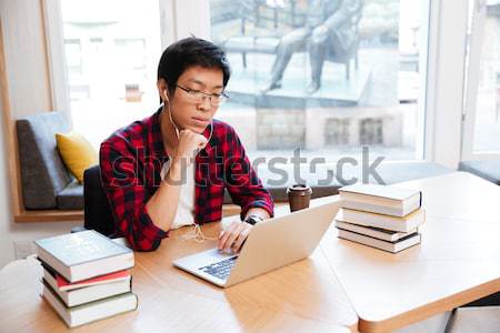 [[stock_photo]]: Homme · utilisant · un · ordinateur · portable · bibliothèque · écouter · musique · heureux