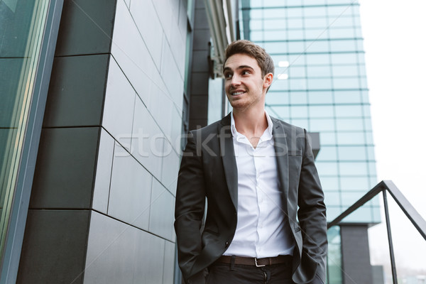 Business man with arms in pockets near the office Stock photo © deandrobot