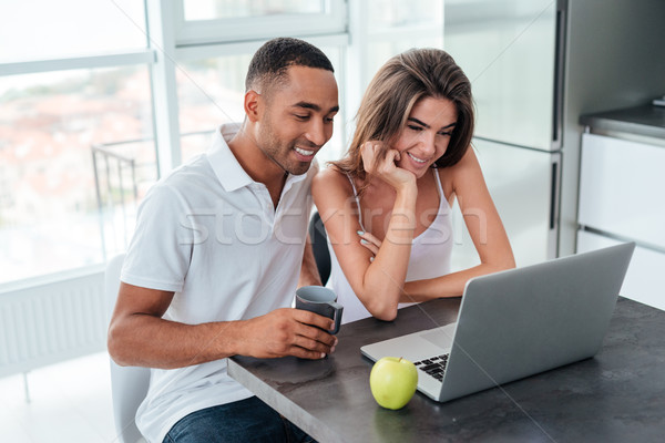 Interracial couple with laptop Stock photo © deandrobot