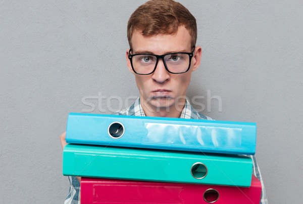 Serious hipster in glasses with folders Stock photo © deandrobot